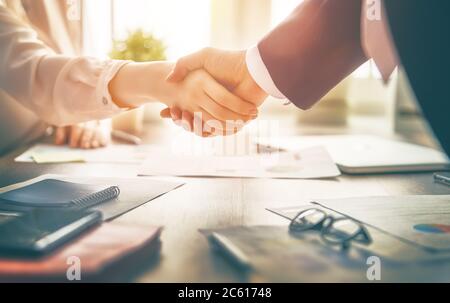 Uomo e donna stanno scuotendo le mani in ufficio. Lavoro di squadra collaborativo. Foto Stock