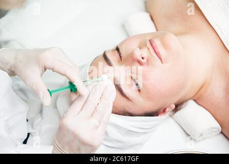 Medico cosmetologo che fa iniezioni biorevitalizzazione in clinica Foto Stock