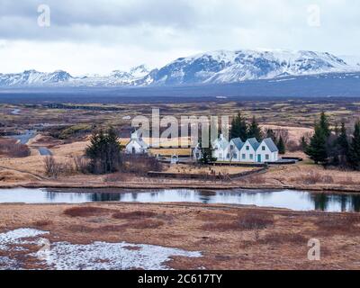 Piccola chiesa e case nel paesaggio del Parco Nazionale di Þingvellir, Islanda Foto Stock