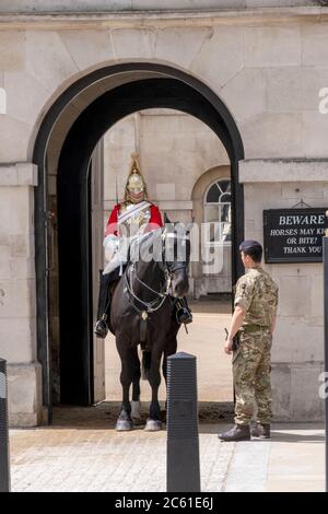 Regno Unito, Londra, Horse Guards. Soldato della Guardia a Cavallo della Regina, reggimento di bagnini in uniforme moderna con un collega montato in abito cerimoniale Foto Stock