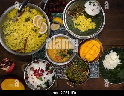 Piatti vegetariani tradizionali dell'India del Sud serviti su un tavolo di legno Foto Stock