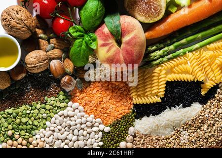 ingredienti e prodotti vegani di base. cereali, legumi, frutta e verdura fresche, oli, semi e noci. dieta sana ed equilibrata isolata su bianco Foto Stock