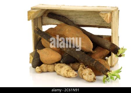 mazzo di verdure miste che escono da una scatola di legno su uno sfondo bianco Foto Stock