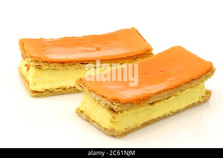 Pasticceria tradizionale olandese chiamata 'tompouce' con bandiera olandese prodotta in particolare per il giorno dei Re il 27 aprile in Olanda su sfondo bianco Foto Stock