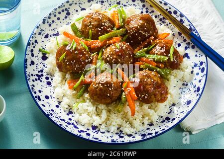 Polpette asiatiche vegane senza carne in salsa dolce e acide con riso e verdure stufate. Pranzo equilibrato o cena sana. cibo di strada Foto Stock