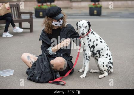 Glasgow, Scozia, Regno Unito. 6 luglio 2020. Nella foto: Un proprietario di cane visto indossare una maschera dalmata stile viso visto con il suo cane dalmata animale domestico nel centro della città. Persone in George Square. Bar e ristoranti riaprono a Glasgow come restrizioni di blocco facile. Da oggi Pub, bar, caffè e ristoranti in Inghilterra, Scozia e Irlanda del Nord sono i clienti che accolgono per la prima volta da quando è iniziato il blocco nel mese di marzo. Credit: Colin Fisher/Alamy Live News Foto Stock