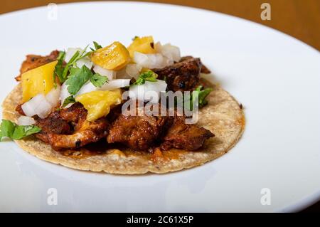 taco al pastor, cibo messicano isolato su un piatto bianco Foto Stock