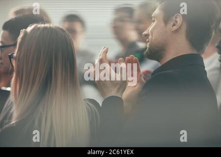 attraverso il vetro. un gruppo di giovani uomini d'affari applaudendo Foto Stock