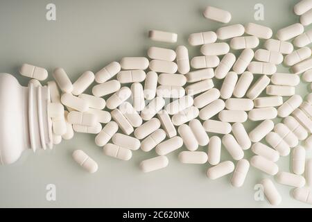 Pillole fuoriuscite dal flacone di pillola, vista dall'alto. Foto Stock