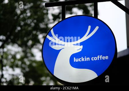 primo piano sul logo del caffè luckin sulla scatola luminosa che si aggetta all'esterno della cabina del caffè. Sfocatura dello sfondo. Un marchio di caffè in forte crescita in Cina Foto Stock