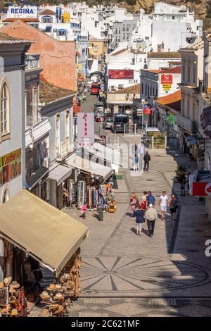 Rua 5 de Ouubro UNA popolare via dello shopping e dei ristoranti conduce a Praia do Túnel (Praia do Peneco), nella città vecchia di Albufeira, Portogallo Foto Stock