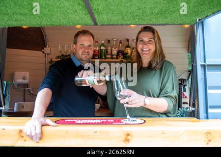 Dorney, Buckinghamshire, Regno Unito. 6 luglio 2020. Per tenere le code dopo la riapertura del pub dopo il blocco di Coronavirus, gli innovativi proprietari di casa Chrys e Hanna Fisher hanno aperto un bar all'aperto nel loro giardino pub al Palmer Arms a Dorney, Buckinghamshire. Il bar è un'antica scatola di cavalli convertita chiamata "bit on the side". Durante il Coronavirus la coppia ha fornito un servizio di arrosto domenicale da togliere alla gente del posto. Credit: Maureen McLean/Alamy Live News Foto Stock