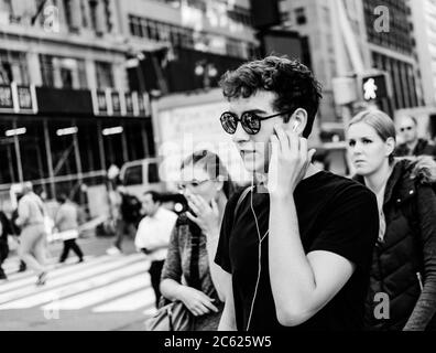 Un adolescente ha visto usare un telefono in un luogo pubblico a New York City durante i primi mesi dell'autunno in una giornata di lavoro molto intensa. Foto Stock