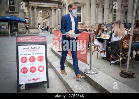 I pasti vengono serviti sulla strada presso l'area ristorante all'aperto di Maggio nel centro di Glasgow, in quanto le aree all'aperto riaprono al pubblico per la prima volta mentre la Scozia continua con la graduale eliminazione delle restrizioni per facilitare l'uscita dalla zona di blocco. Foto Stock