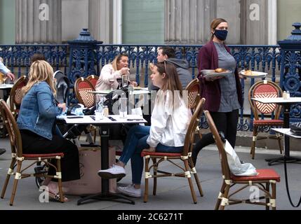 I pasti vengono serviti sulla strada presso l'area ristorante all'aperto di Maggio nel centro di Glasgow, in quanto le aree all'aperto riaprono al pubblico per la prima volta mentre la Scozia continua con la graduale eliminazione delle restrizioni per facilitare l'uscita dalla zona di blocco. Foto Stock