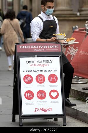 I pasti vengono serviti sulla strada presso l'area ristorante all'aperto di Maggio nel centro di Glasgow, in quanto le aree all'aperto riaprono al pubblico per la prima volta mentre la Scozia continua con la graduale eliminazione delle restrizioni per facilitare l'uscita dalla zona di blocco. Foto Stock