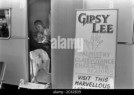 Gipsy Fortune Teller anni '70 Regno Unito. Gipsy Lee leggere il palmo di un cliente. Palmistry, chiaroveggenza e letture di carattere. All'incontro delle corse ippiche del Derby Day. Sulla collina, Epsom Downs, Surrey 1974. REGNO UNITO HOMER SYKES Foto Stock