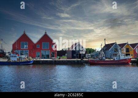 Europa Paesi Bassi Tour attraverso i canali, magazzini colorati nel piccolo porto olandese a Zoutkamp Foto Stock