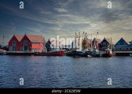 Europa Paesi Bassi Tour attraverso i canali, magazzini colorati nel piccolo porto olandese a Zoutkamp Foto Stock