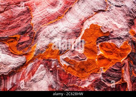 La superficie di pietra arenaria rossa del canyon conosciuta come al Siq all'ingresso della città rosa di Petra in Giordania. Foto Stock