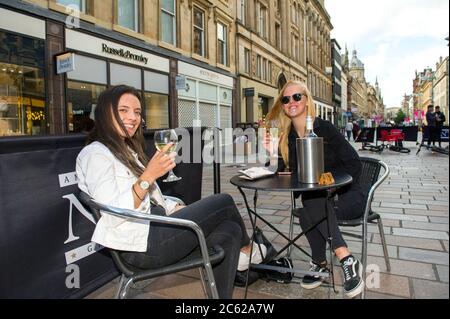 Glasgow, Scozia, Regno Unito. 6 luglio 2020. Nella foto: Due Signore bevono vino bianco nel miglio stile di Glasgow, Buchanan Street. Da oggi Pub, bar, caffè e ristoranti in Inghilterra, Scozia e Irlanda del Nord sono i clienti che accolgono per la prima volta da quando è iniziato il blocco nel mese di marzo. Credit: Colin Fisher/Alamy Live News Foto Stock