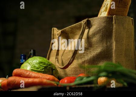 borsa ecologica realizzata in tela naturale con bancarelle di cibo e verdure su un tavolo di legno. Concetto ecologico. Foto Stock