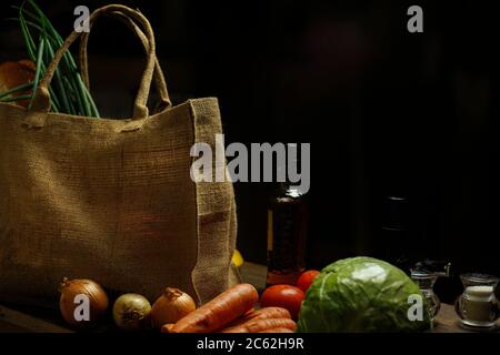 borsa ecologica realizzata in tela naturale con bancarelle di cibo e verdure su un tavolo di legno. Concetto ecologico. Foto Stock