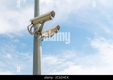 Telecamere di sicurezza su un palo di cemento contro il cielo blu. Foto di alta qualità Foto Stock