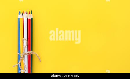 Concetto di educazione e ritorno a scuola. Matite colorate sullo sfondo giallo con spazio per il testo. Foto Stock