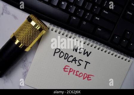 Nuovo Podcast Eposide scrivere su un libro isolato tavolo di legno. Foto Stock