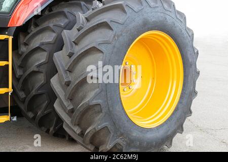 Due ruote grandi da un trattore o da un primo piano di macchine agricole. L'immagine del battistrada. Foto Stock