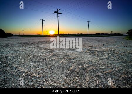 I pneumatici del trattore cinge i dettagli con i pali del telefono e il sole al tramonto, Doniphan, Nebraska USA Foto Stock