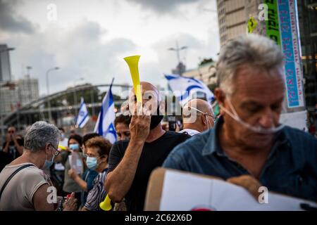 Tel Aviv, Israele. 06 luglio 2020. Un attivista del movimento anticorruzione soffia un corno durante una protesta contro le nuove leggi applicate dal governo del primo ministro israeliano Benjamin, in mezzo a un salto nei casi di Coronavirus (covid-19). Credit: Ilia Yefimovich/dpa/Alamy Live News Foto Stock