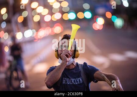 Tel Aviv, Israele. 06 luglio 2020. Un attivista del movimento anticorruzione soffia un corno durante una protesta contro le nuove leggi applicate dal governo del primo ministro israeliano Benjamin, in mezzo a un salto nei casi di Coronavirus (covid-19). Credit: Ilia Yefimovich/dpa/Alamy Live News Foto Stock