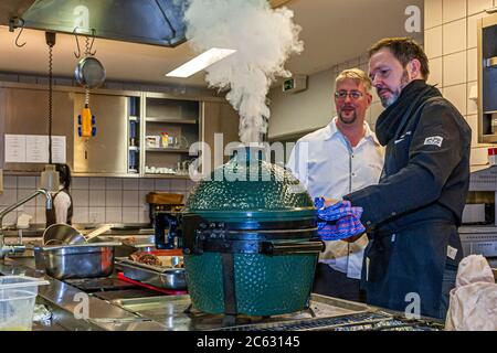 Tedesco 3 stelle Michelin chef Marco Müller con Big Green Egg. Uno dei segreti del brisket tenero di manzo è l'ordine 'verso': Prima scaldare nel forno a fuoco basso e poi grigliarlo caldo nel suo proprio fumo appena prima di tagliarlo Foto Stock