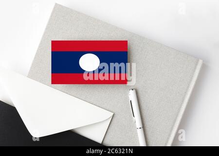 Laos bandiera su sfondo minimalista lettera. Busta nazionale con penna bianca e notebook. Concetto di comunicazione. Foto Stock