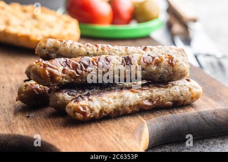 Salsicce bianche grigliate su tagliere di legno. Foto Stock