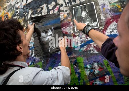 Mosca, Russia. 15 agosto 2015 i fan del cantante rock e poeta Viktor Tsoi appendono ritratti dell'idolo sul Muro Tsoi in via Arbat a Mosca, il 25° anniversario della morte del cantante, la Russia. Il Muro di Tsoi è un muro coperto di graffiti a Mosca, dedicato al musicista Viktor Tsoi e alla sua band Kino Foto Stock