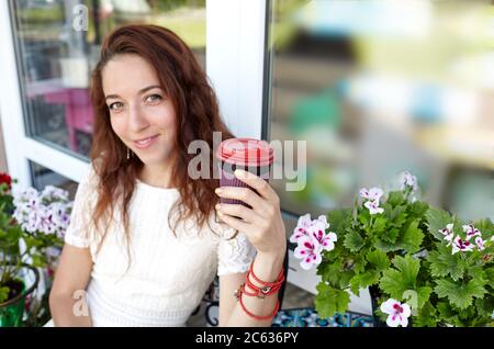 Bella bella donna bevande cocee nel caffè. Pausa caffè. Smartphone sul tavolo. Immagine sfocata, messa a fuoco sulle mani Foto Stock