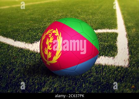 Bandiera Eritrea sulla palla in posizione di calcio d'angolo, sfondo campo di calcio. Tema nazionale del calcio sull'erba verde. Foto Stock