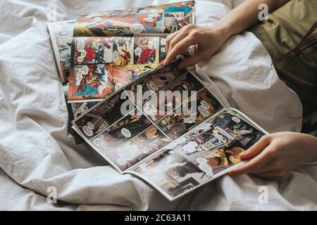 Donna legge fumetti a letto. Foto Stock