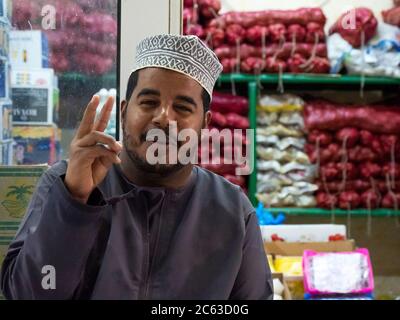 Venditore nel suoq di frutta e verdura, o mercato, a Sinaw, Sultanato di Oman. Foto Stock