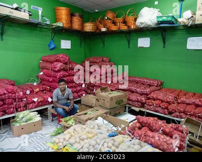 Venditore nel suoq di frutta e verdura, o mercato, a Sinaw, Sultanato di Oman. Foto Stock