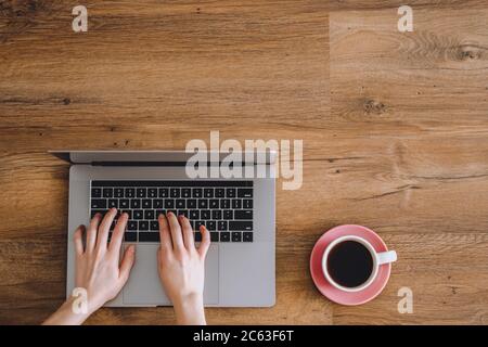 Le mani femminili stanno digitando sulla tastiera del laptop. Foto Stock