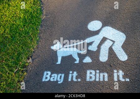 BAG IT Bin ha dipinto il segno sul sentiero, incoraggiando i proprietari di cani a pulire dopo il loro animale domestico Foto Stock