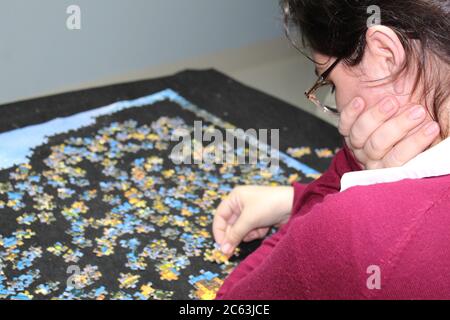 Puzzle di assemblaggio mani sul tavolo Foto Stock