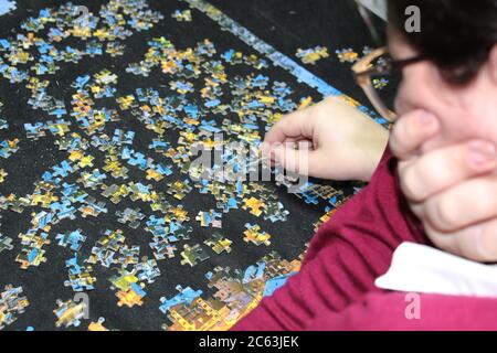 Puzzle di assemblaggio mani sul tavolo Foto Stock