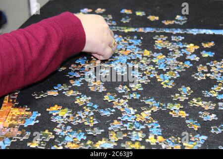 Puzzle di assemblaggio mani sul tavolo Foto Stock