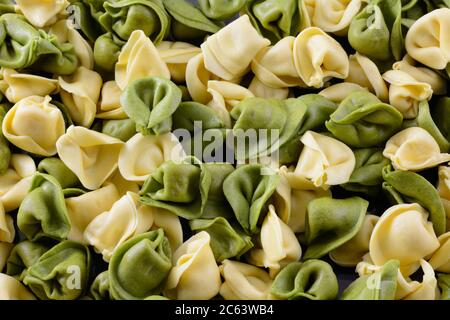 Primo piano di spinaci e tortellini di formaggio di grano con fondo di pasta alimentare Foto Stock