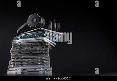 Cuffie Hi-Fi su una pila di CD su sfondo nero con spazio per la copia. Foto Stock